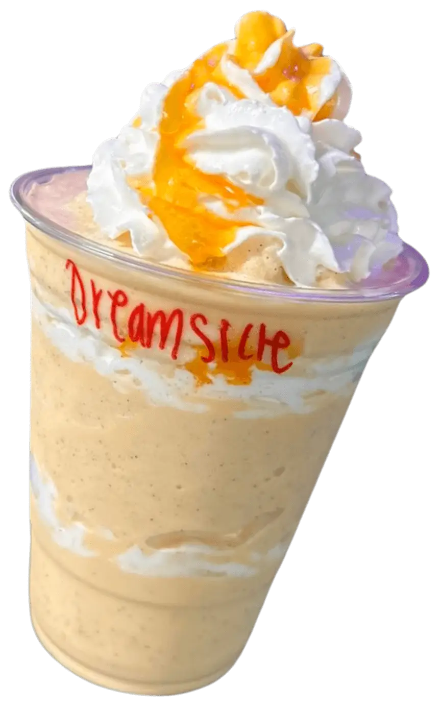 A creamy orange beverage topped with whipped cream and a drizzle of orange sauce, labeled "Dreamsicle" in red.